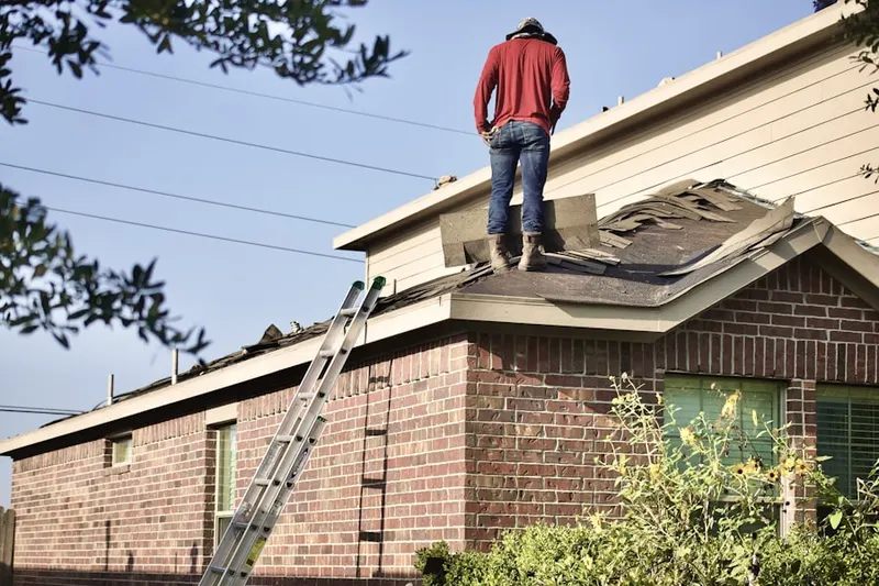 Professional roofer working on a residential roof in Dutch Village South